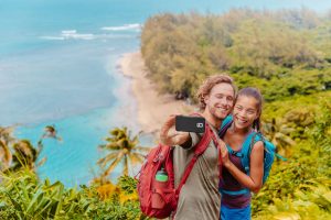 couple posing for a selfie on a trail by the ocean